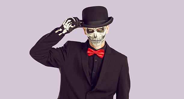 istock Handsome man with skeleton makeup touching his hat in greeting 2230127404