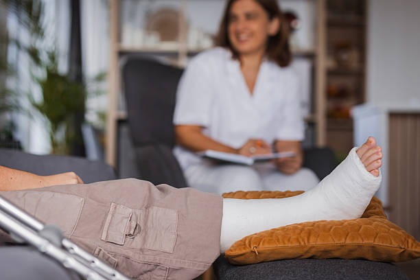 istock Patient with broken leg resting comfortably while doctor takes notes 2230128154