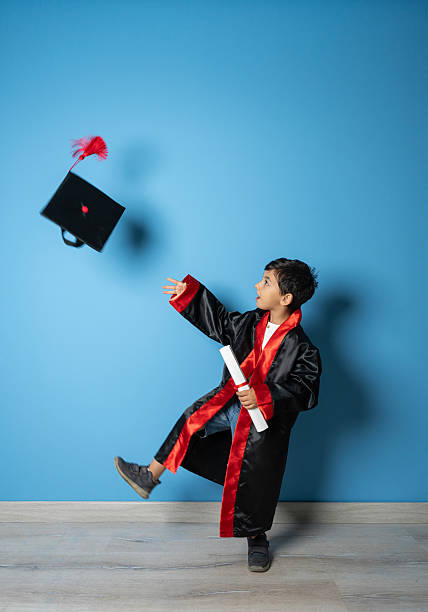 istock Cute Kid in Graduation Cap Throwing Hat in the Air with Joy and Confidence 2230129010