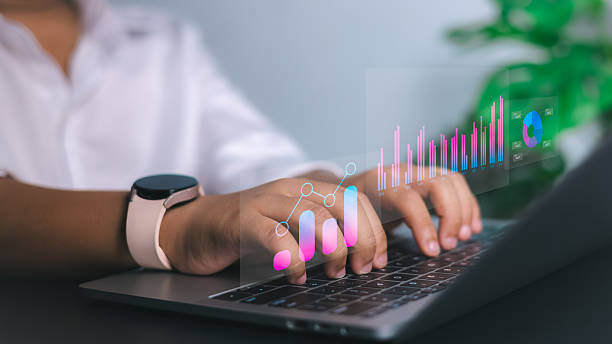 istock Data analysis, business growth, and digital technology solutions. Close-up of hands typing on a laptop with holographic bar graphs, charts, and analytics. 2230129880