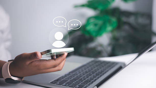istock Online communication, messaging technology, and modern digital interaction in business or personal use. Close-up of a person holding a smartphone with chat icons. 2230129881