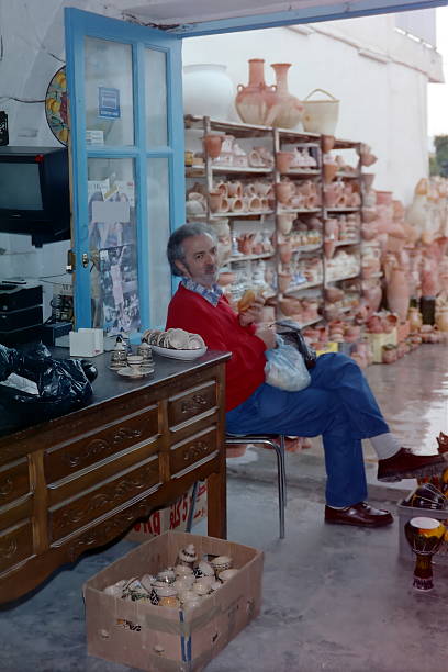 A tourist takes a snack break while waiting to be served.\nPlease note that these images were taken in 1998 and converted from negatives.