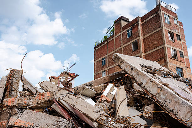A photo of an urban demolition and reconstruction project. In the background, buildings are either about to be demolished or are currently being demolished, depicting the demolition of old buildings. Demolition of dilapidated homes makes way for new development.