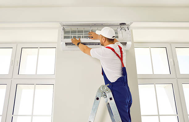istock Worker installs ventilation system in appartment room or office from ladder. 2230133182