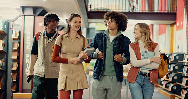 istock People, students and walking with books in library of education, research project and study. Smile, group and friends talking with textbooks, learning advice and scholarship offer of exam preparation 2230133408