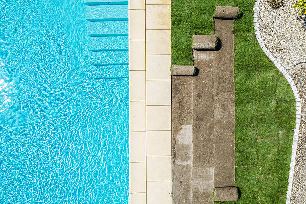 istock Refreshing Swimming Pool Area With Lounge Spots Beside Grassy Landscape 2230134347