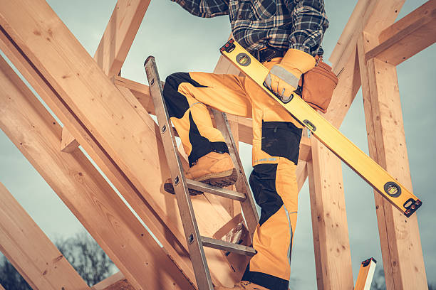 istock Construction Worker Uses Ladder to Install Wooden Beams at a Building Site 2230134363