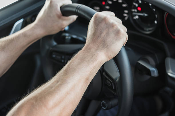 Action of the driver's hand is beeping or pushing the horn on car steering wheel. Close-up.