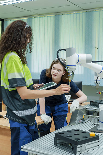 istock female engineers collaborate in smart factory lab using tablet and robotic interface for automation training program demonstrating teamwork and hands on skill development 2230136473
