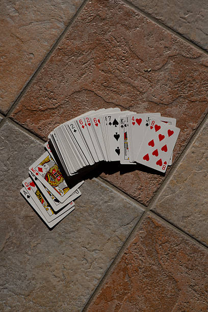Playing cards scattered wildly across the floor, playing poker