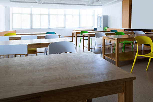 An empty classroom with long wooden desk