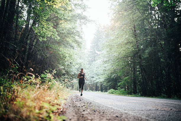 istock Mature Woman Running Rural Forest Road 2230139282
