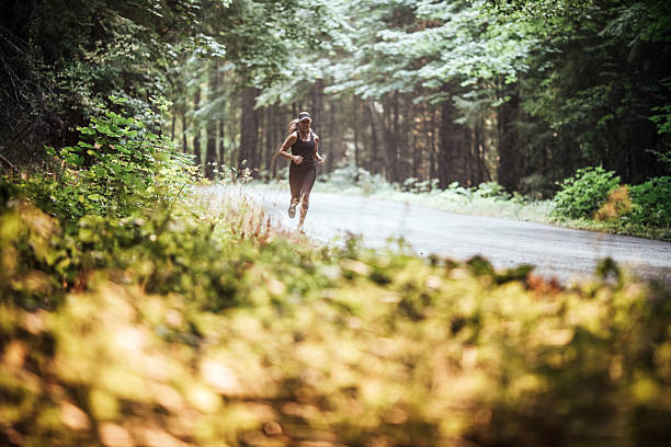 istock Mature Woman Running Rural Forest Road 2230139291