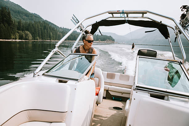 istock Mature Woman Driving A Boat While Husband Wakeboards 2230139313