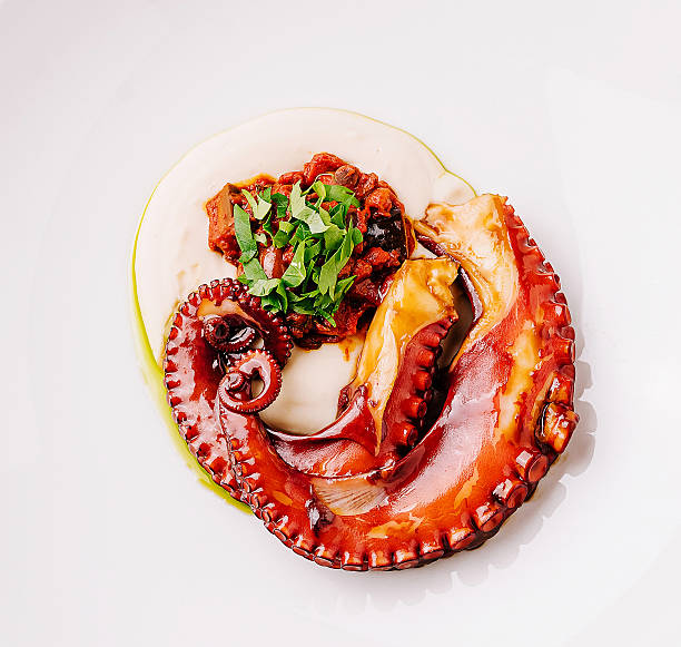 istock Deliciously cooked octopus served elegantly on a white plate with garnishing 2230142019
