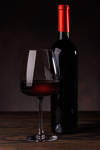 istock Wine glass filled with wine beside a bottle 2230142688