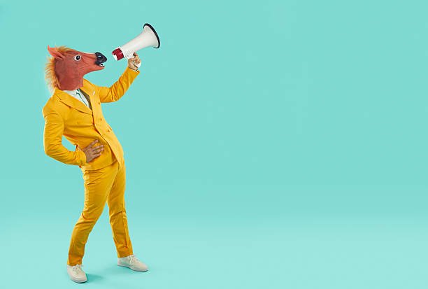 istock Funny businessman with horse head shouting through megaphone 2230144464