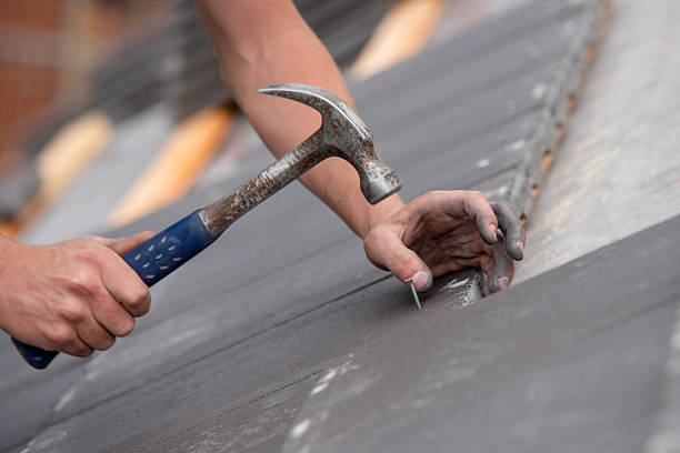 istock Roofing conctractror working on steep roof, carefully nailing down slate tiles while ensuring proper alignment 2230144814