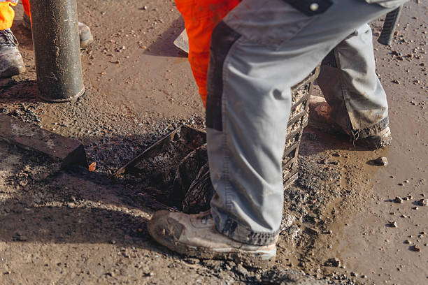 istock Roadworkers opened clogged road gully and cleaning it from debris and dirt using vac-ex and power jet wash 2230146413