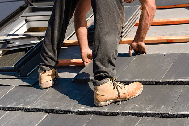 istock Roofer installing roof tiles using nails and hammer 2230146456