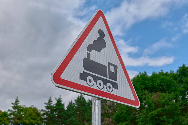 A triangular warning sign features a steam train icon