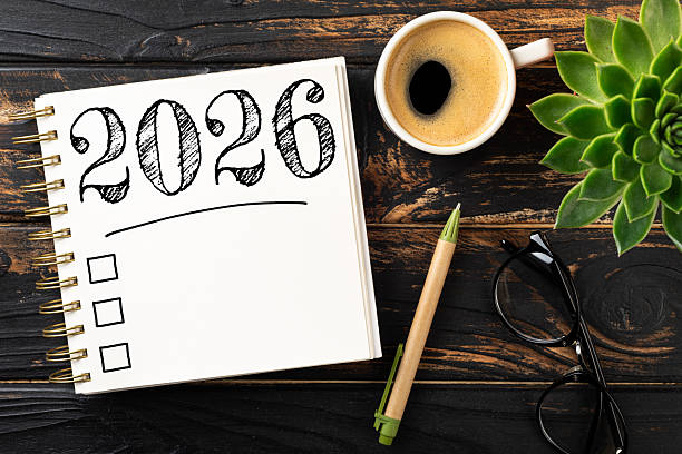 istock New year resolutions 2026 on desk. 2026 resolutions list with notebook, coffee cup on wooden table. Goals, resolutions, plan, action, checklist concept. New Year 2026 template 2230148393
