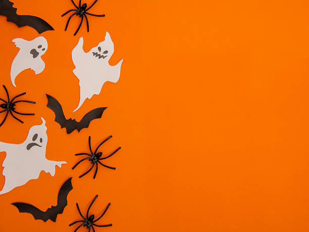 istock Halloween themed elements, pumpkins, a ghost figurine, bats, spiders and a spider web on an orange background 2230149528