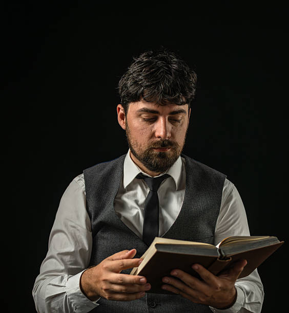 Man reading book near window