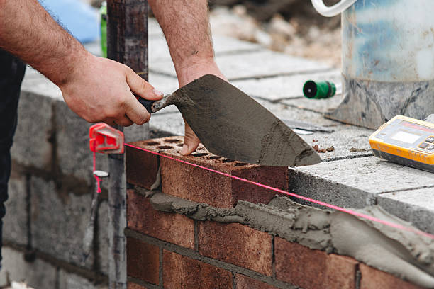 istock Close-up of Skilled bricklayer laying bricks with trowel on construction site 2230149955