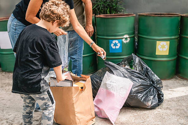 istock Family recycling paper and plastic in separate bins 2230150011
