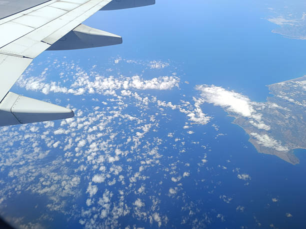 Aerial view from airplane window over the Mediterranean coast with wing in frame