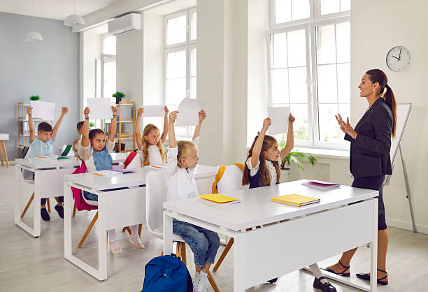 istock Whole class happily raised their hands knowing answer to question asked. 2230153398