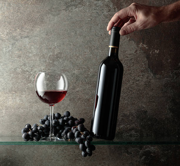 istock Hand reaches for a bottle of red wine. 2230154425