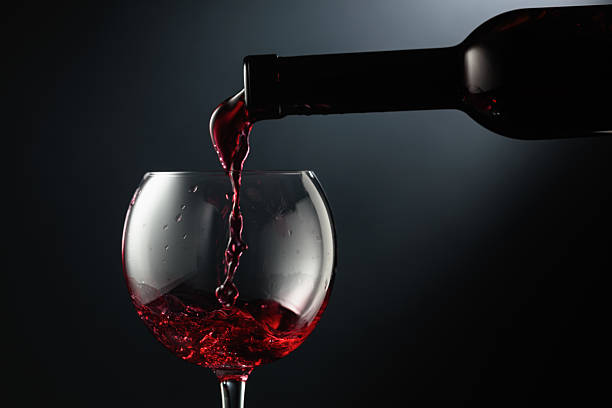 istock Pouring red wine into a wine glass. 2230154453