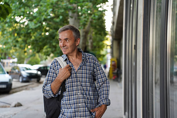 istock Senior man walking through city and window shopping 2230155461