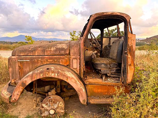 istock An old and decayed car in a cloudy evening as the sun sets 2230157362