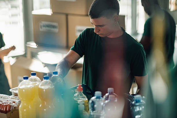 istock Volunteer sorting food and drinks donations in a warehouse 2230159441