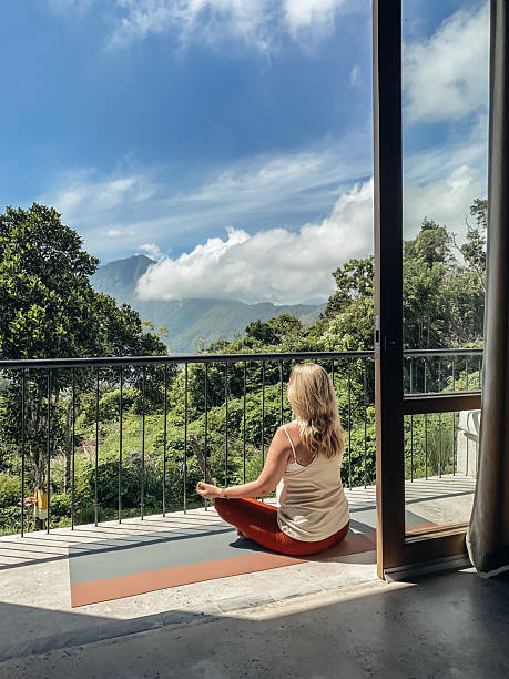 istock Middle-aged woman practicing yoga on a balcony 2230160373