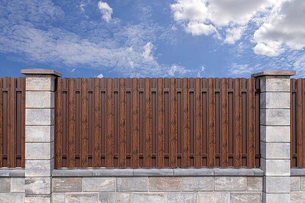 istock Brown metal picket fence with stone pillars 2230160937
