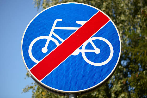 Circular blue traffic sign with a red diagonal line over a bicycle symbol, indicating the end of a designated cycling path or route. Used to inform cyclists they must leave the dedicated bike lane.