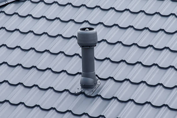 Plastic roof vent pipe on gray metal tile roofing
