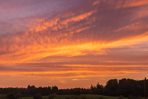 Sun is setting on horizon over land. Wilderness area from German countryside.