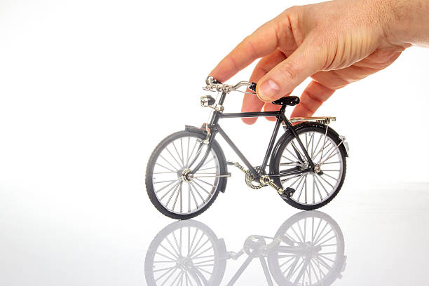 istock man hand on a bicycle model on a white background. cycling concept 2230175805