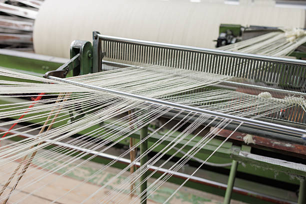 istock Wool warp threads passing the reed on an industrial weaving loom 2230176236