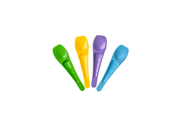 four white asian spoons each with a different color ring on a small white tray on blue placement