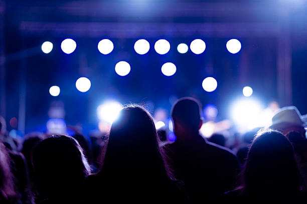 istock Crowd enjoying a music concert with stage lights 2230179340
