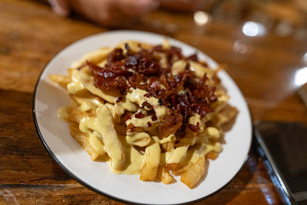 istock French fries with cheese sauce and bacon on white plate 2230179481
