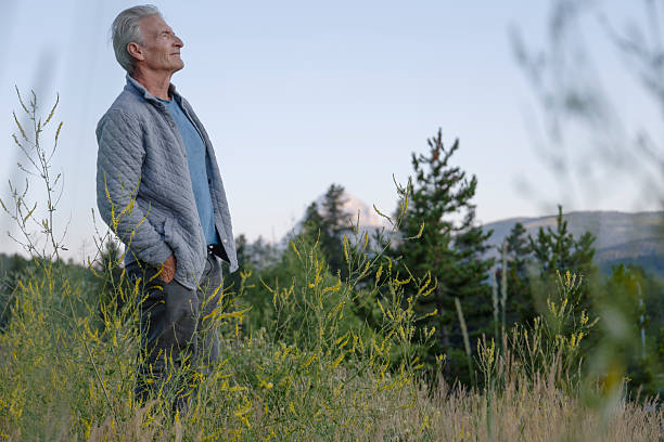 istock Mature man relaxes in mountain meadow at sunrise 2230179489