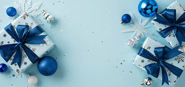 istock Christmas-themed composition featuring neatly wrapped gift boxes adorned with blue ribbons, decorative ornaments, snowflakes, and baubles in a bright and festive arrangement 2230179515