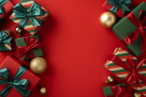 istock Festive Christmas presents with decorative wrapping and golden baubles arranged over a vibrant red backdrop 2230179525
